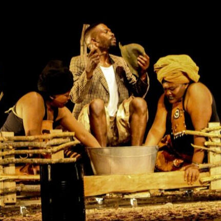 Man being washed by two women on stage